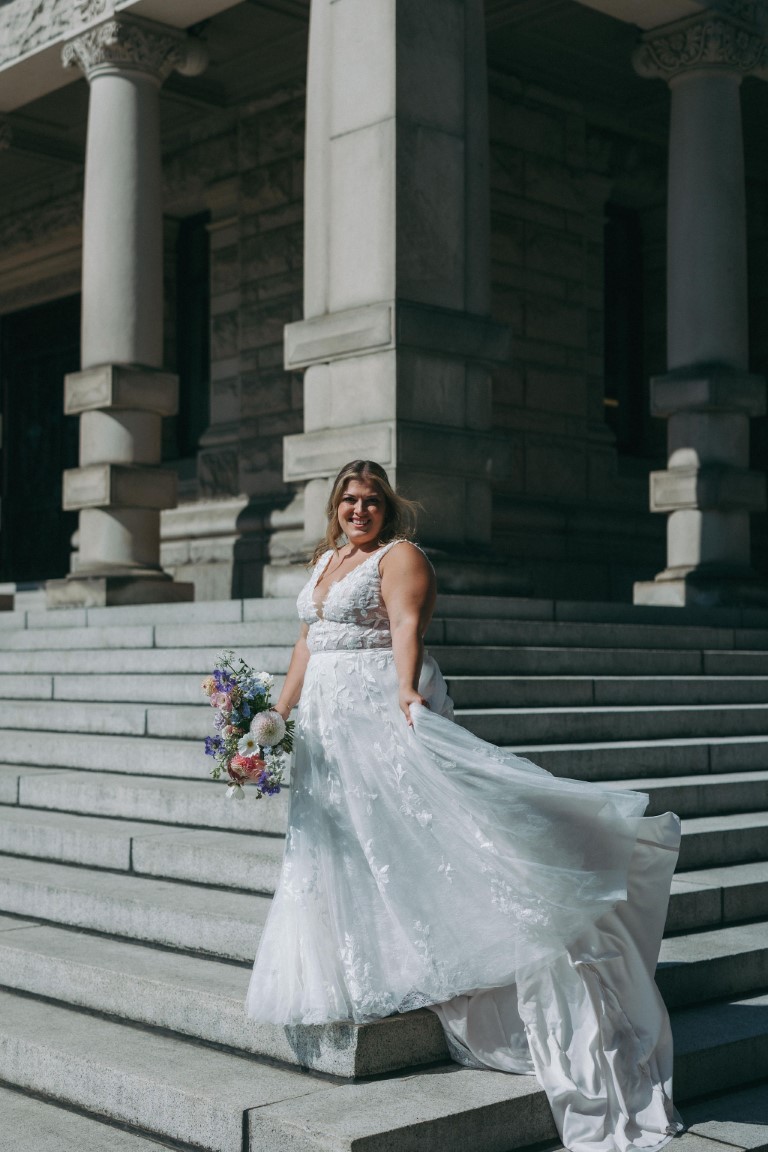 Bride wears Lillian West gown on the Parliament Building steps on Vancouver Island