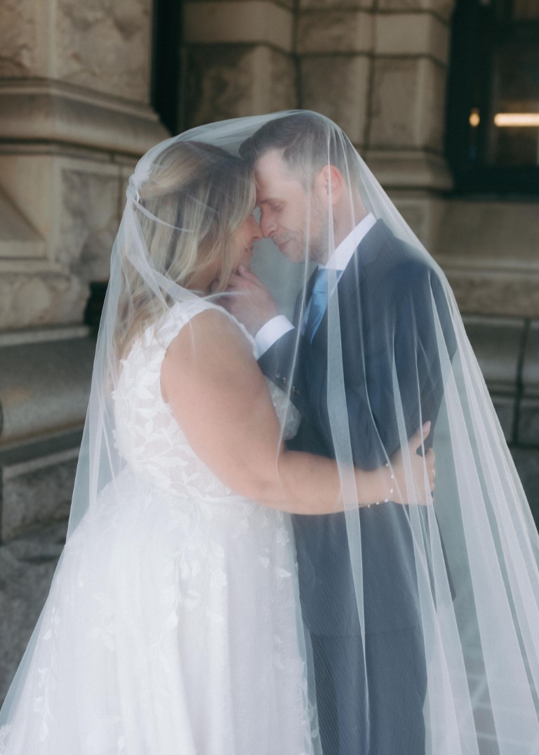 Newlyweds under bride's veil by Robyn Paige Photography