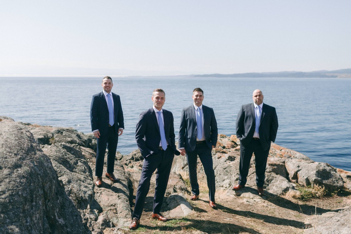 Groom and groomsman pose on Vancouver Island ocean point