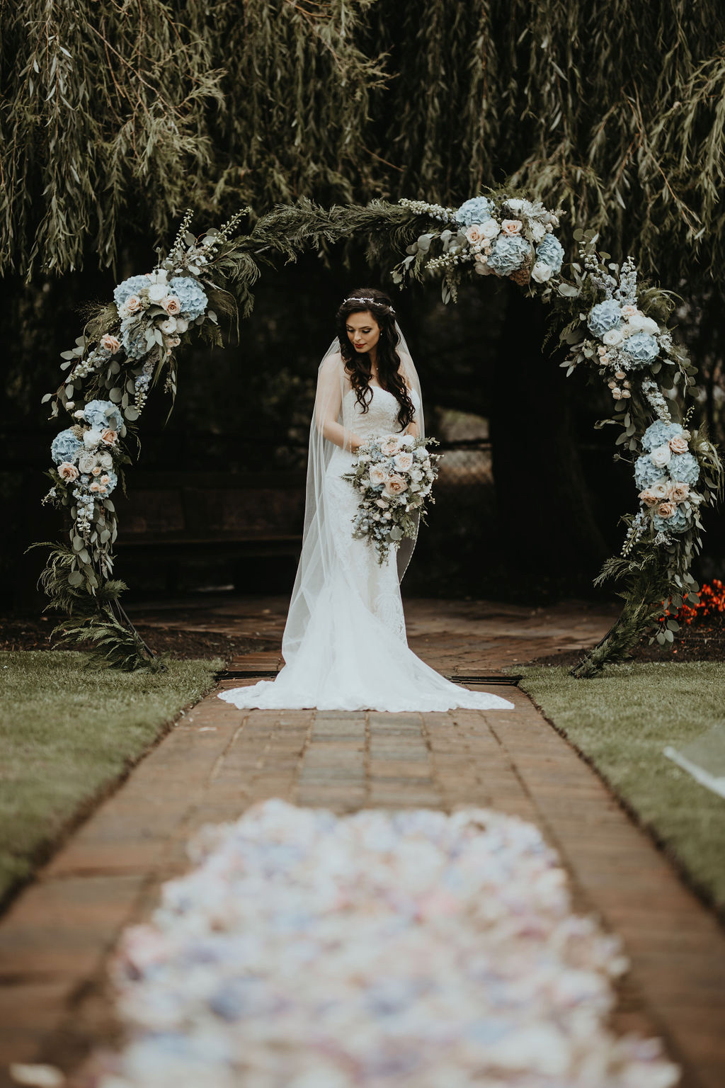 bride in front of white floral backdrop by Rivkah 