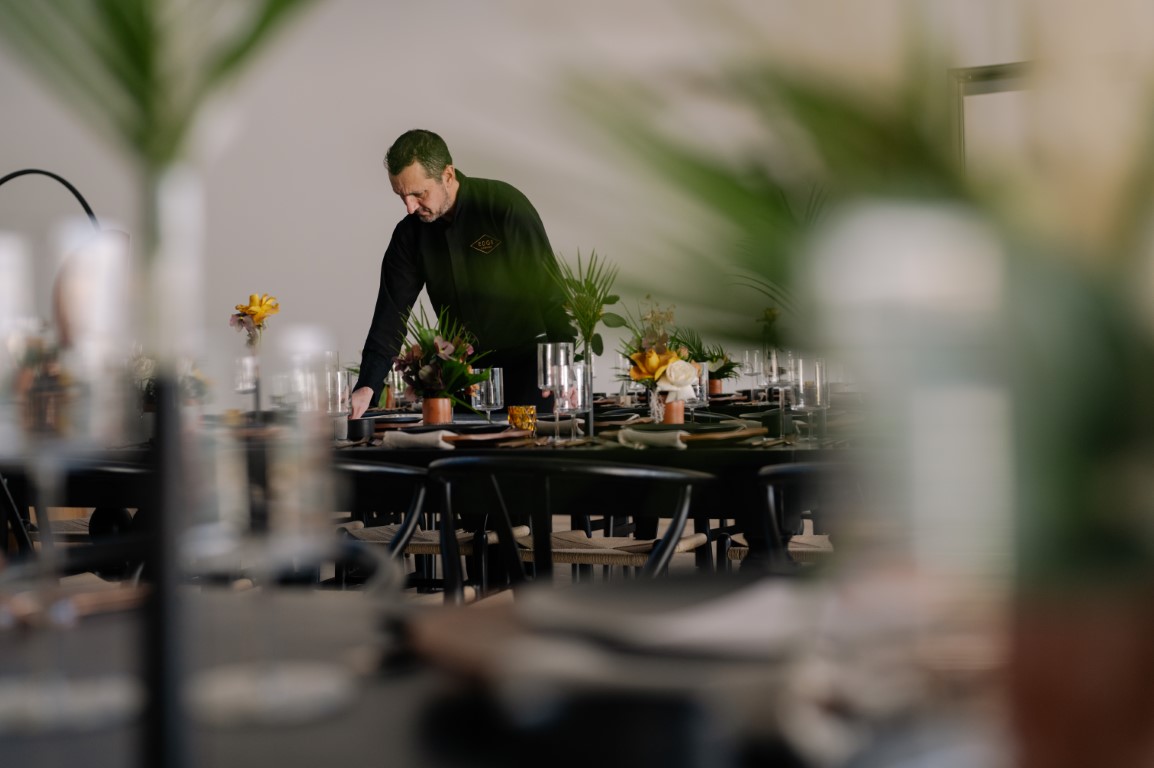 chef looks over set tables from Edge Catering Vancouver