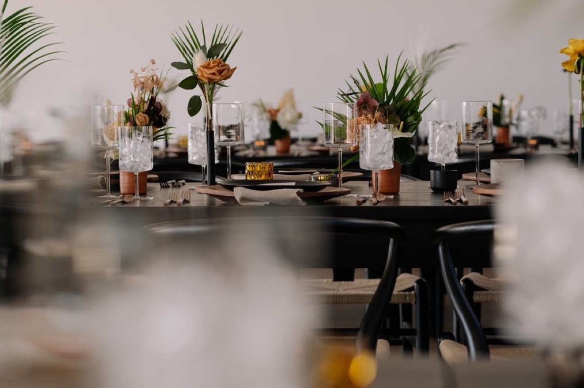 palm leaves and orange tropical flowers on black tables