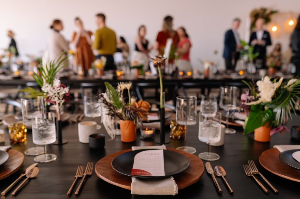 Guests mingle around minimalist decor wedding tables at The Polygon