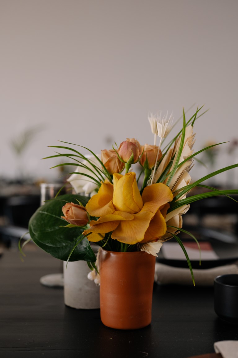 orange flowers and palm leaves at wedding reception