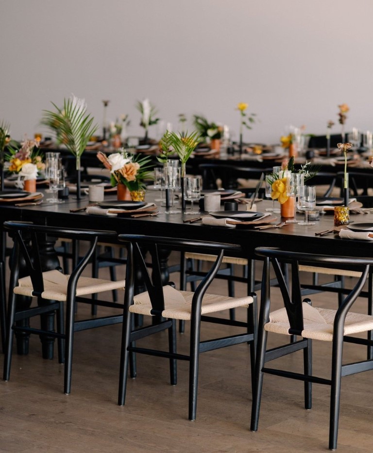 black tables and chairs with palm leaf decor