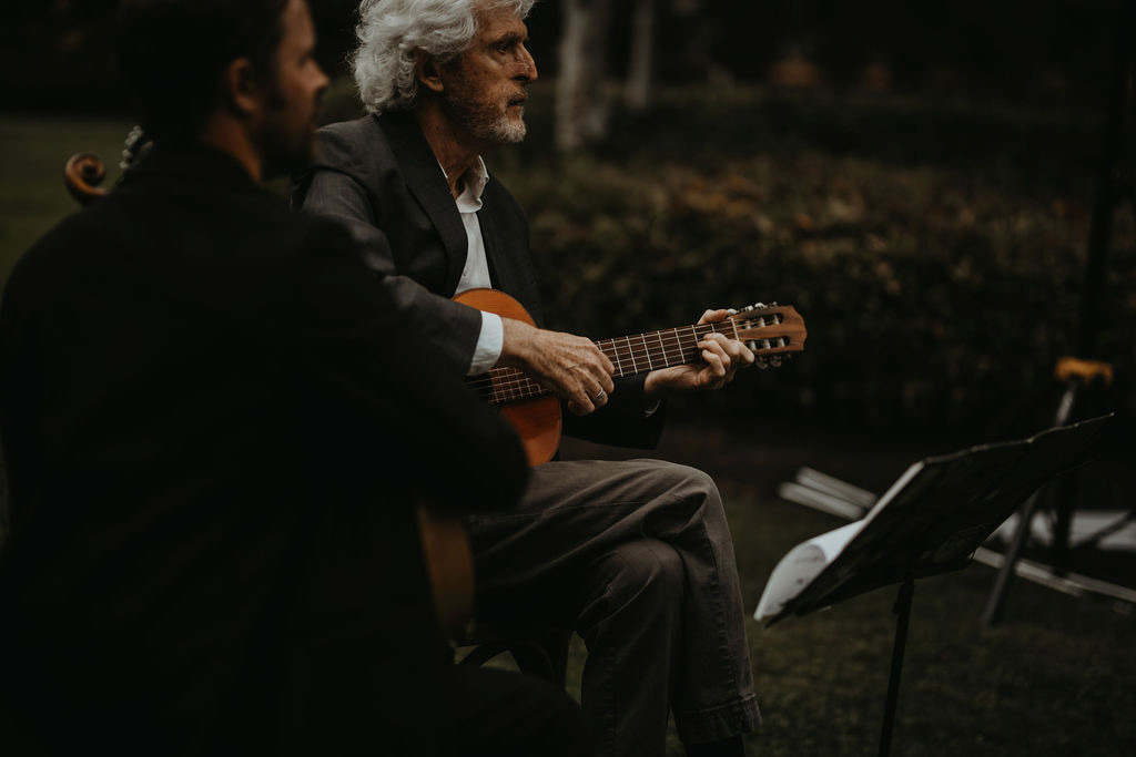 Musician sits under tree by Rivkah Photo