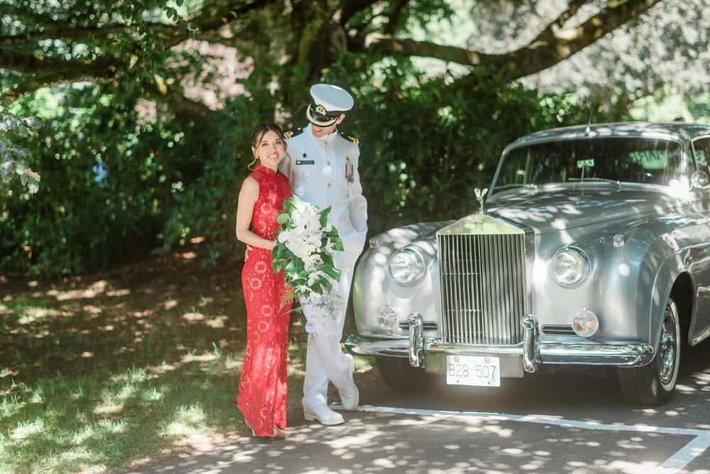 Bride and groom in front of vintage white car