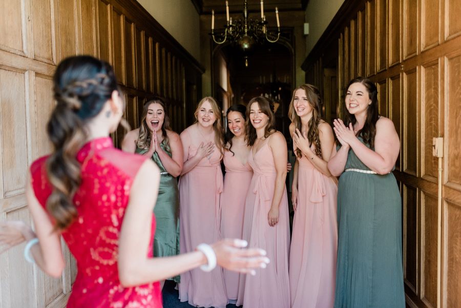 bridesmaids first look at bride in red gown