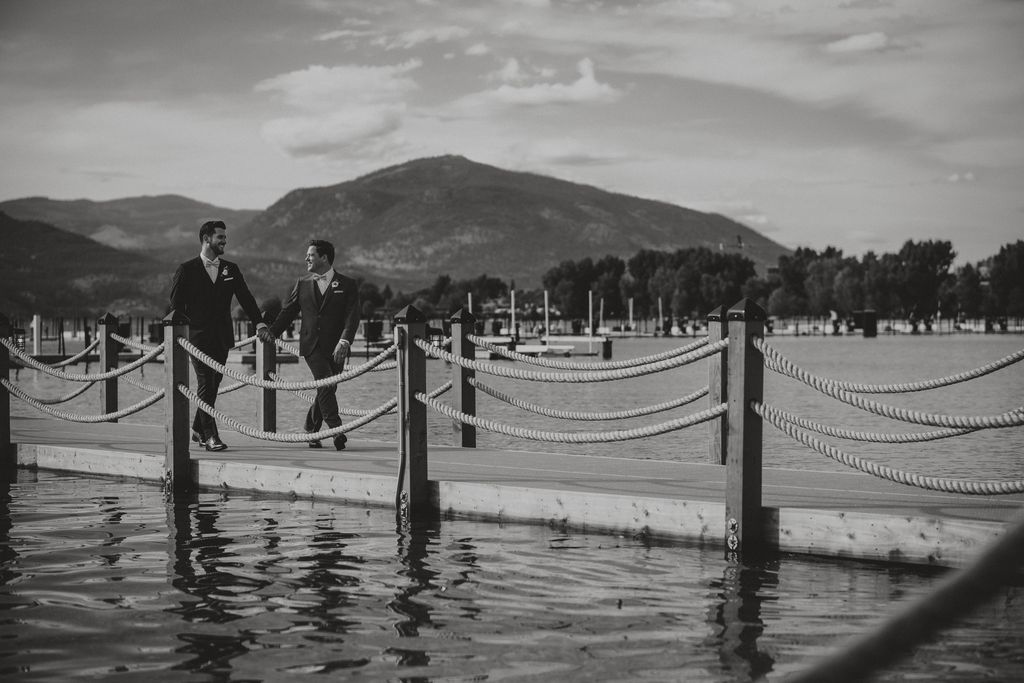 Grooms walk along lake dock in Kelowna