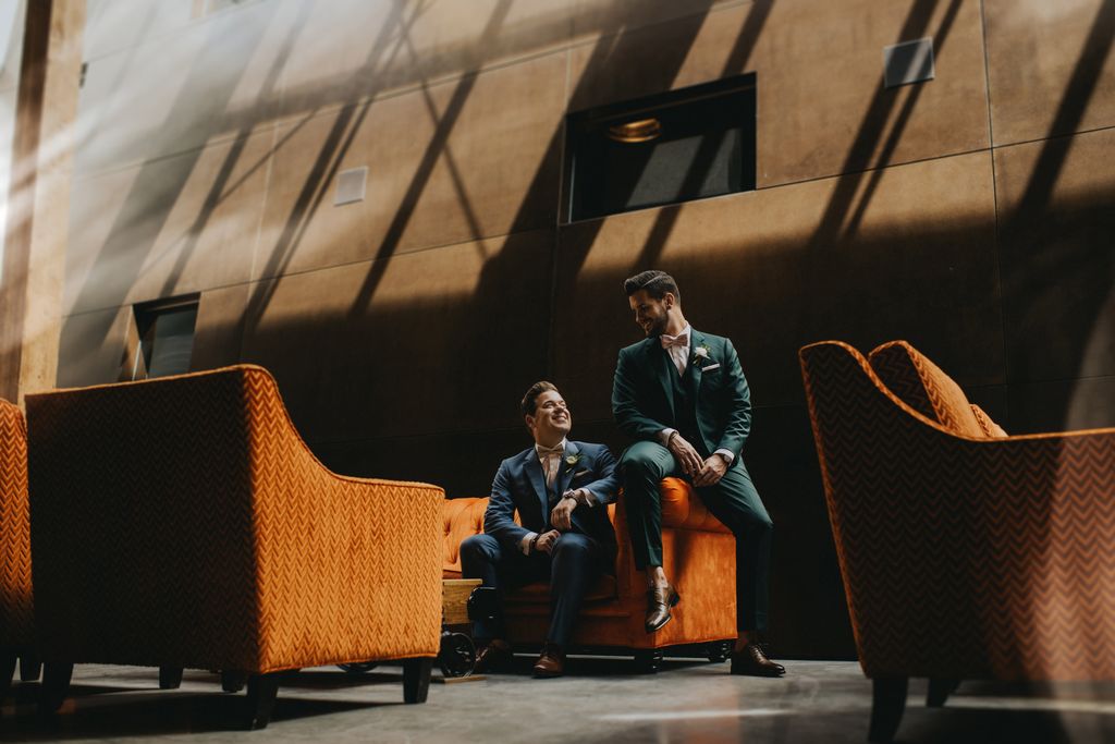 Grooms sit on orange chairs at Sandhill Winery Kelowna