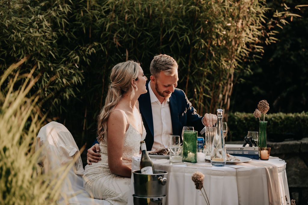 Newlyweds at sweetheart table at Poet's Cove