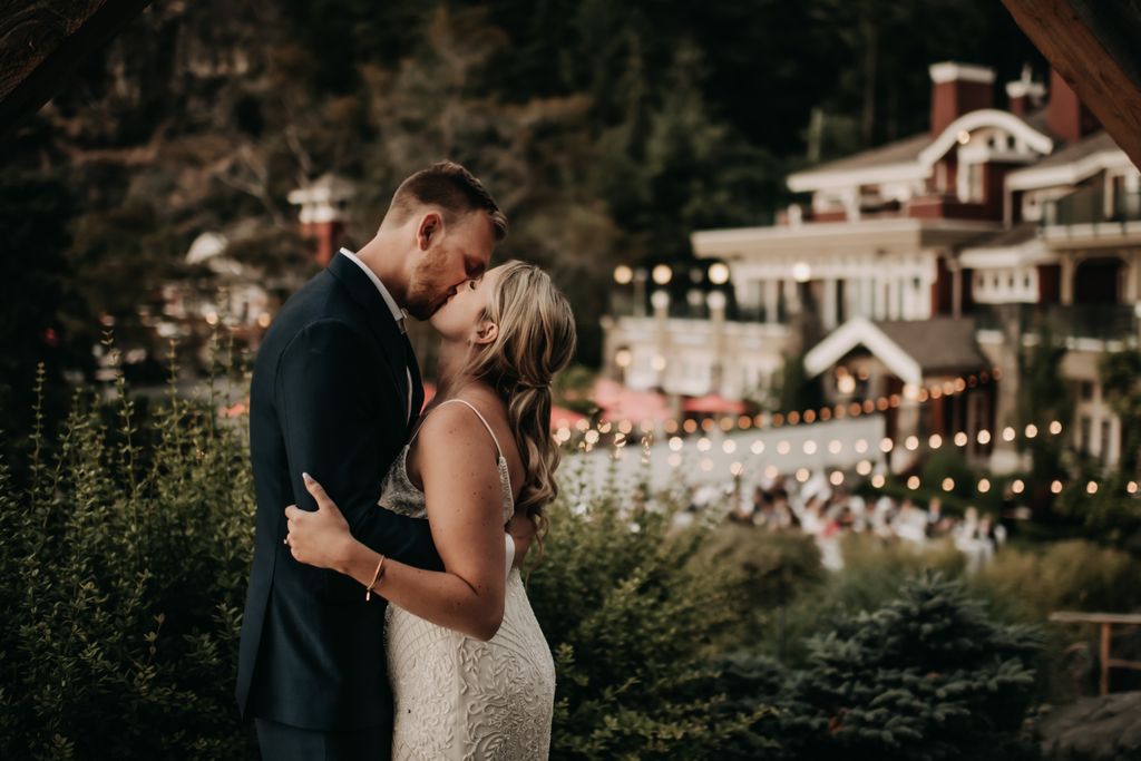 Newlyweds kiss with Poet's Cove Resort as backdrop