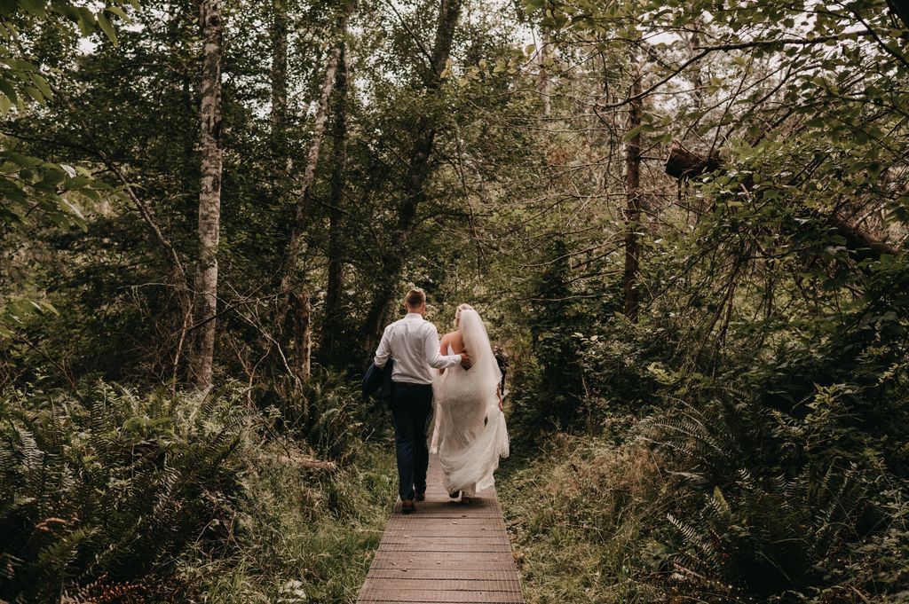 Newlyweds walk forest path at Poet's Cove