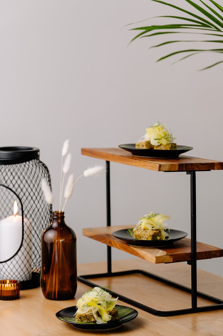 Appetizers on shelf next to brown glass bottle by Bespoke Decor Vancouver