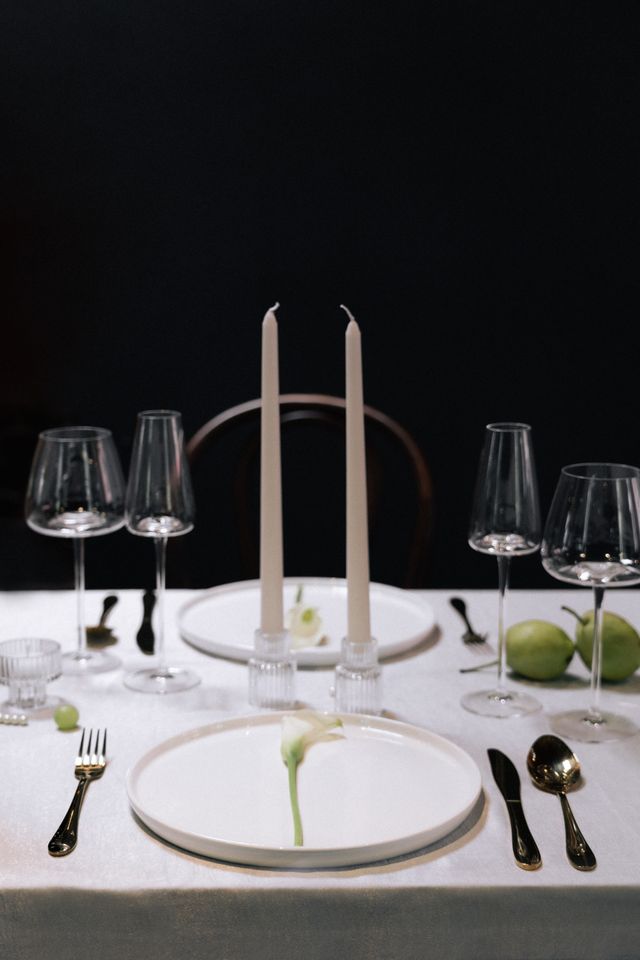 white candles with grapes, pears and pearls on minimalist wedding table