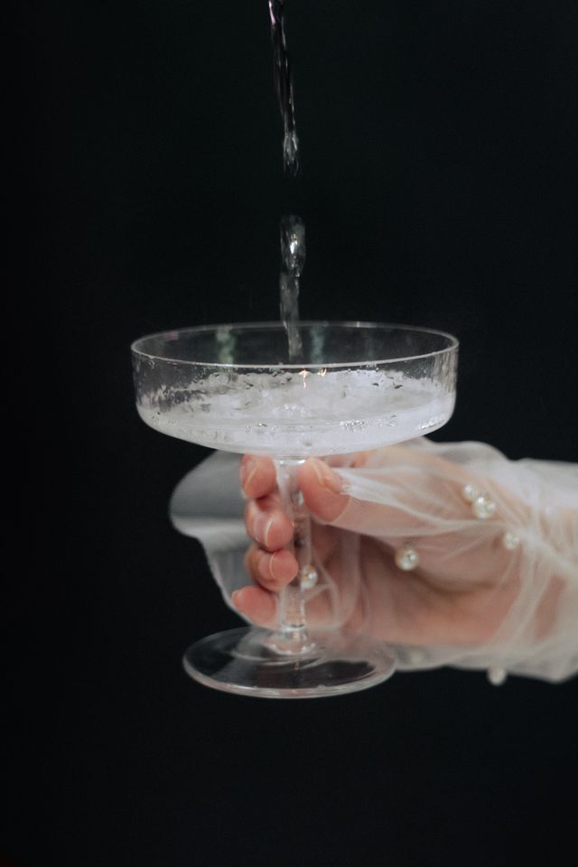 Bride holds champagne glass 