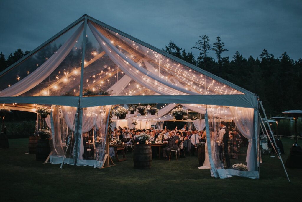 Wedding tent lit up in the night by Black and White Rentals Vancouver Island