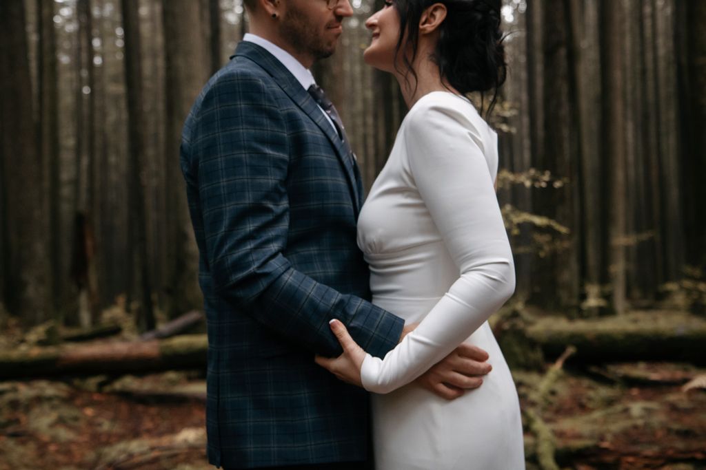 A newlywed embrace among the fir trees of BC