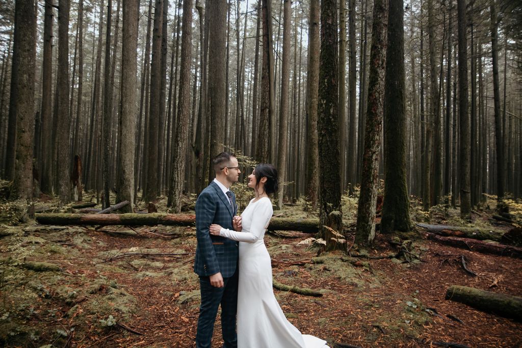 Bride in white lace gown and groom in rainforest