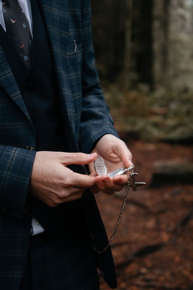 Groom holds ring at rainforest wedding