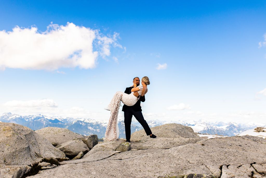 Groom lifts bride on top of Vancouver mountains by Esther Moerman Photo