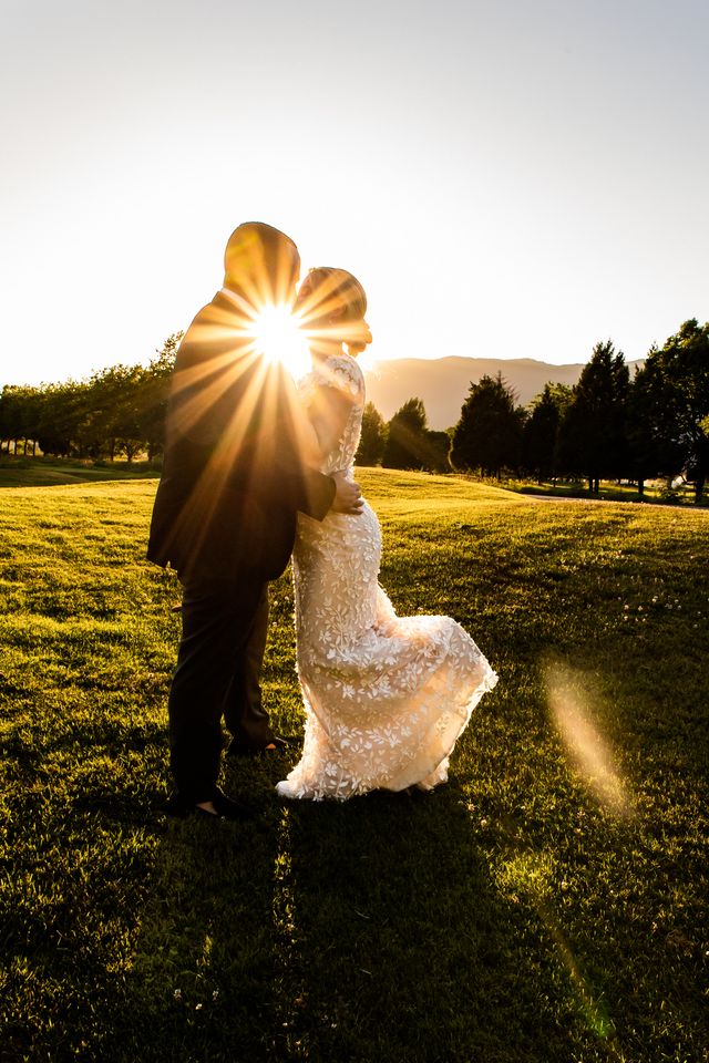 Newlyweds kiss in sunset by Esther Moerman