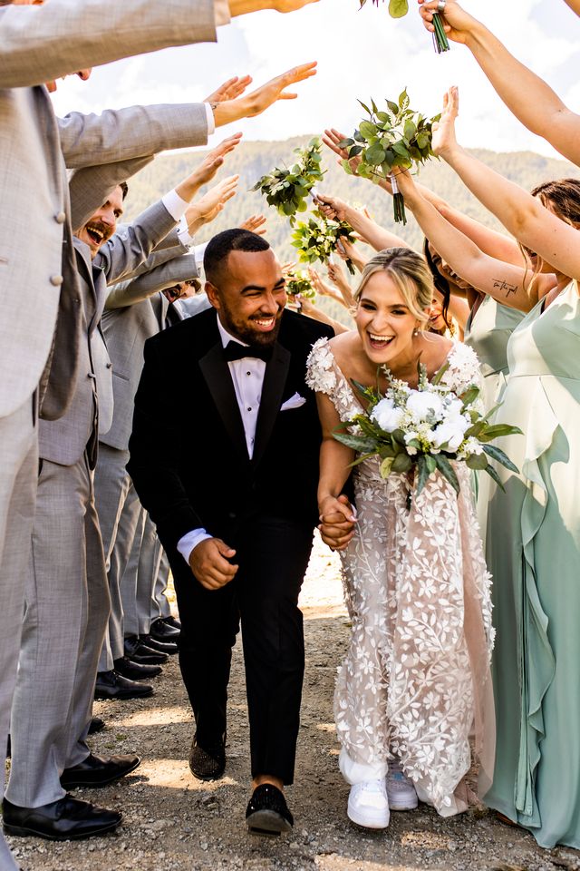 Newlyweds in bridal party arch