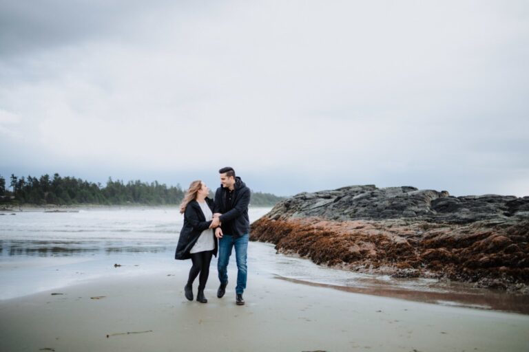 Engaged couple hand in hand on Tofino beach