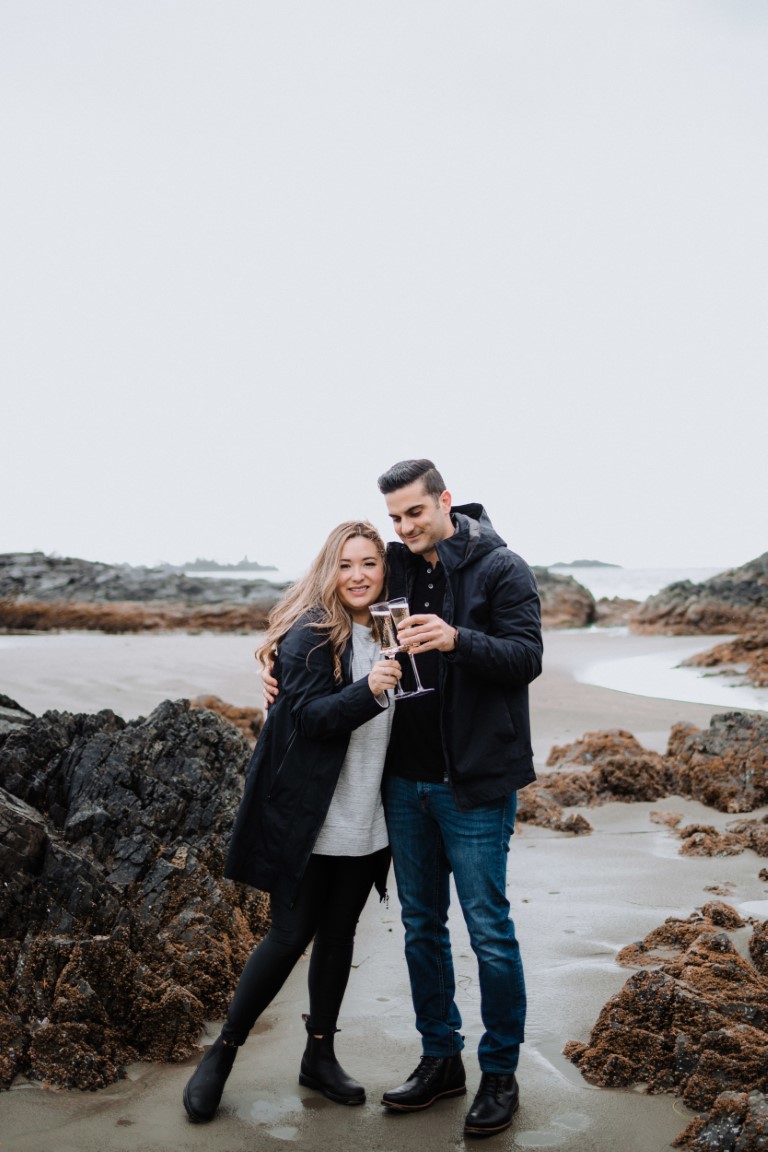 Engaged couple pop cork on champagne