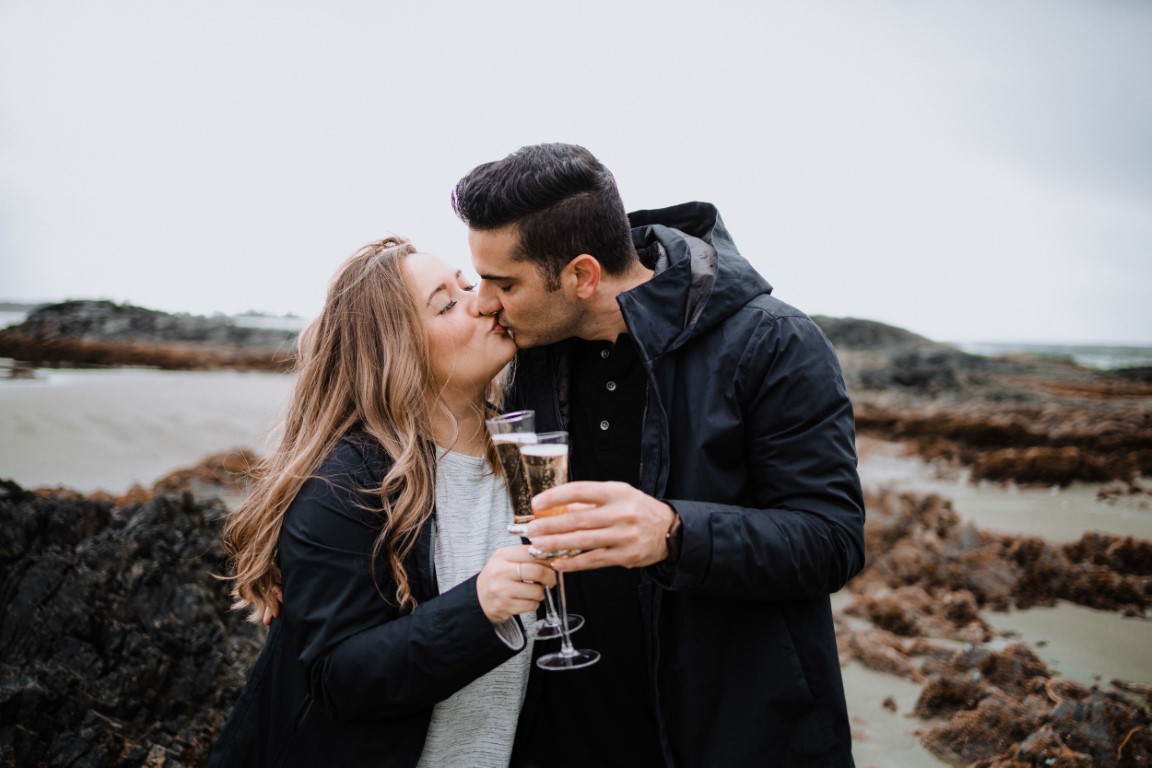 Couple share champagne on Tofino beach