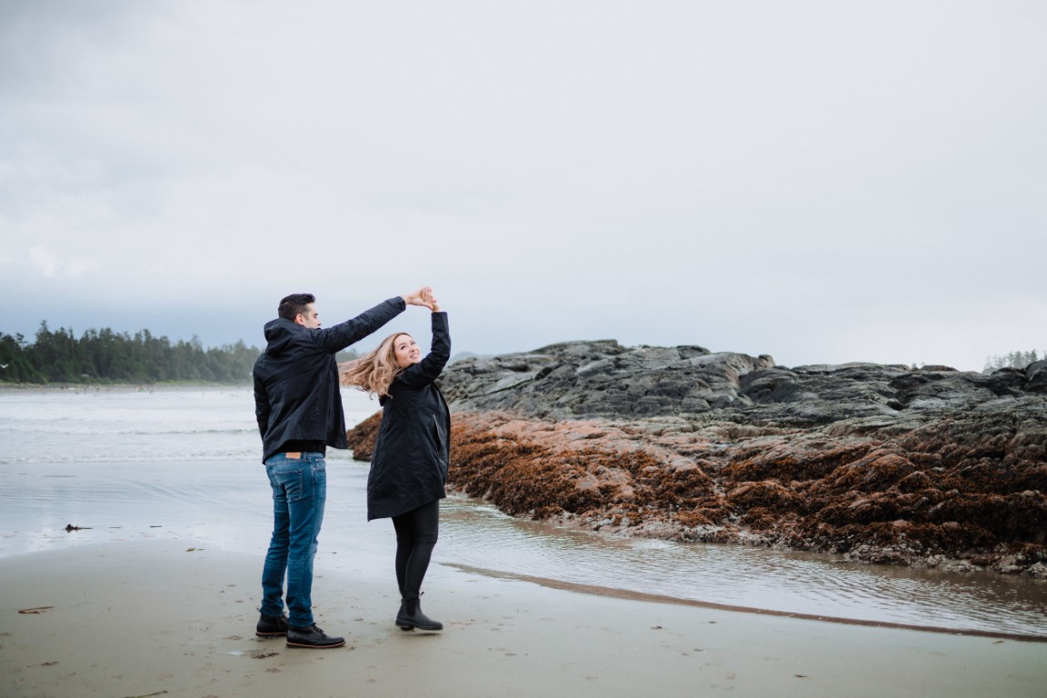 Engaged couple dance on Tofino beach