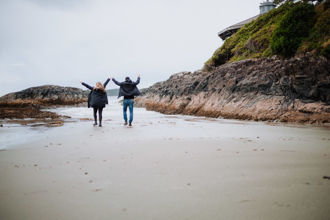 Engaged couple run along Wick Inn beach