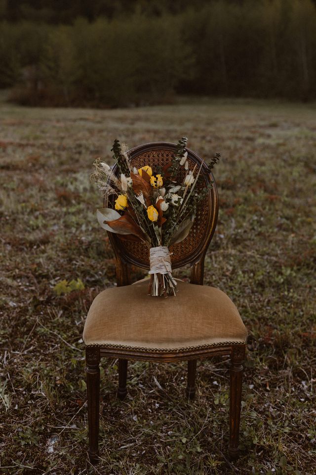 Fall bridal bouquet on chair in field