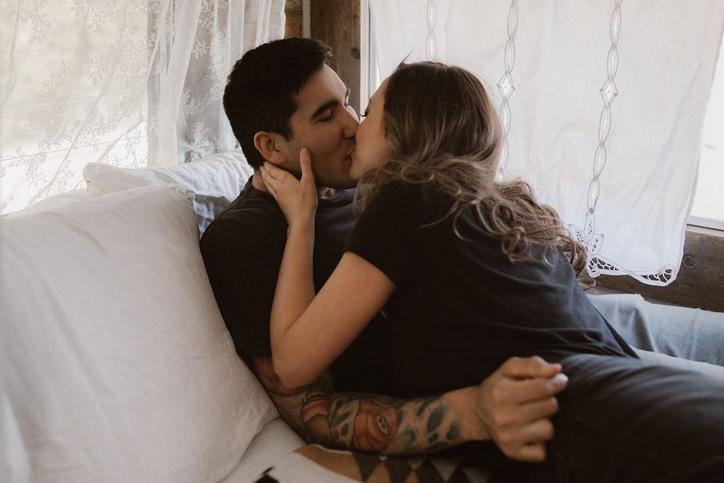 engaged couple in black tshirts embrace in retro trailer