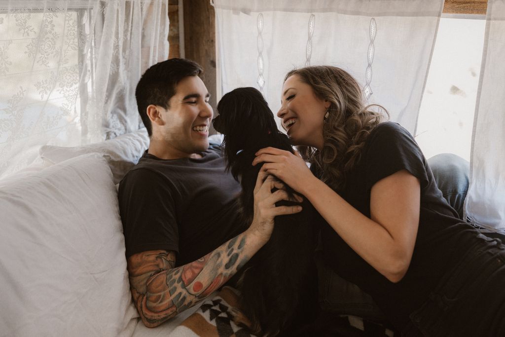 Engaged couple and dog in vintage trailer