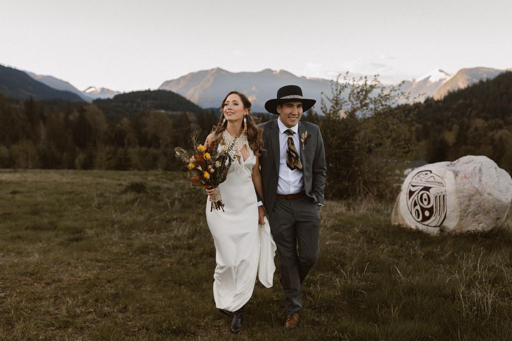 Indigenous eloping couple in field with mountains