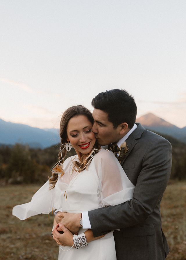 Newlyweds embrace in field