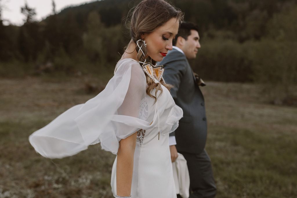 Indigenous couple walk along field after ceremony