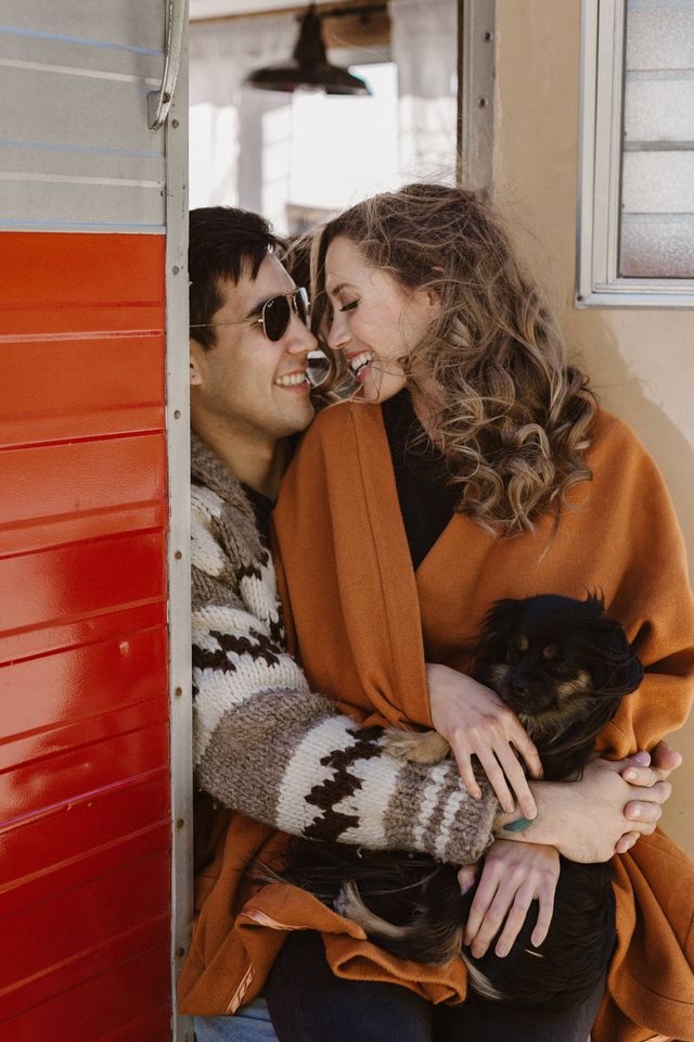 Engaged couple cozy up together in vintage trailer