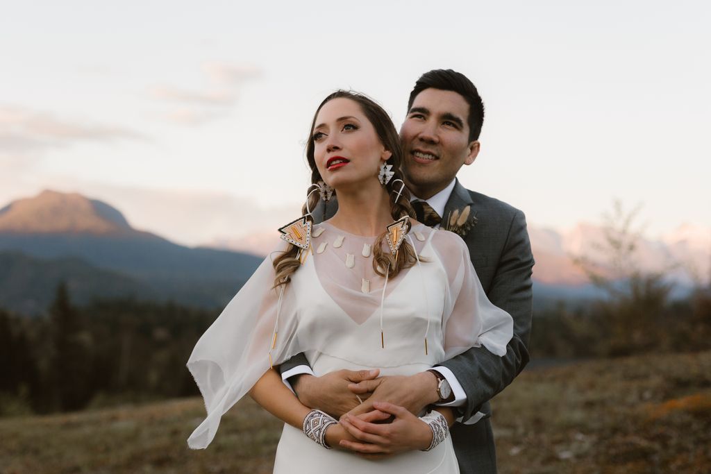 Groom holds Cree bride in field