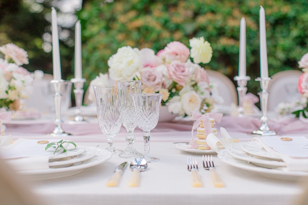 Blush pink and white flowers in vases along reception table