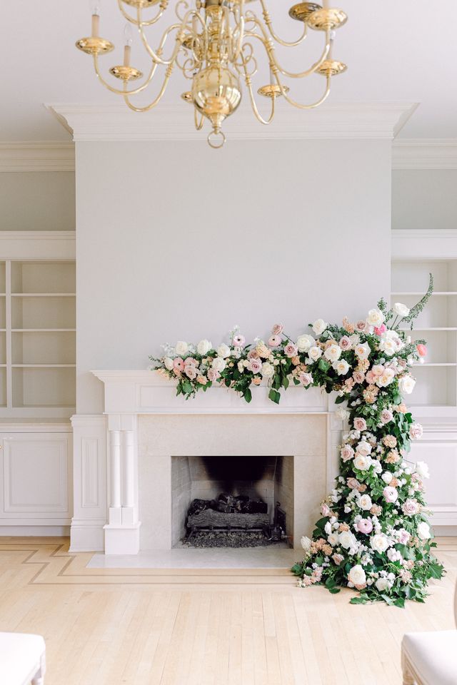 Flowers draped over fireplace mantel for wedding ceremony Ivy May Floral Design Vancouver