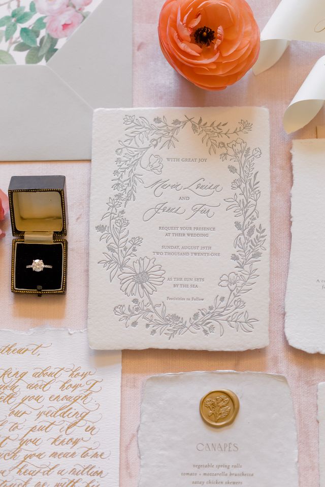 Wedding invite on table by ceremony rings