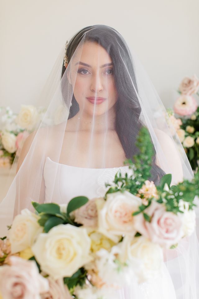 Bride in veil holding a pink bouquet