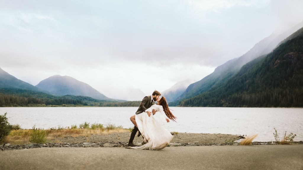 Newlyweds kiss at lake edge in BC