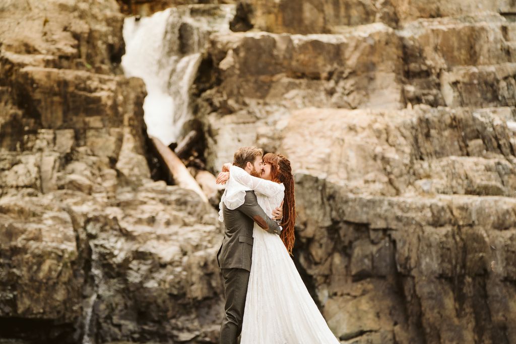 Eloping couple by rock wall