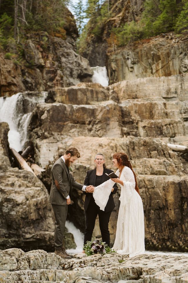 Newlyweds ceremony by cliff wall