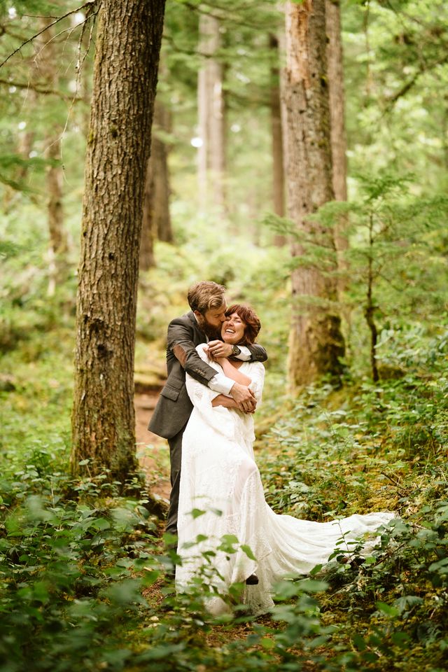 Newlyweds walk along forest path at Strathcona Park Lodge