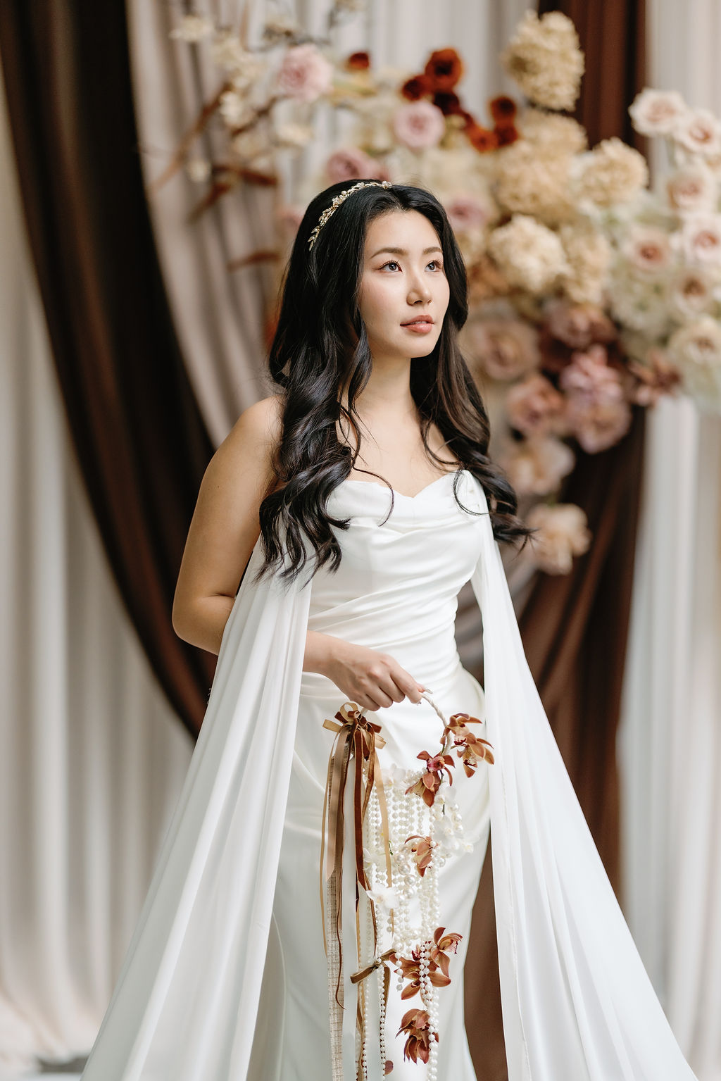 Bride holds bouquet in front of blush roses 