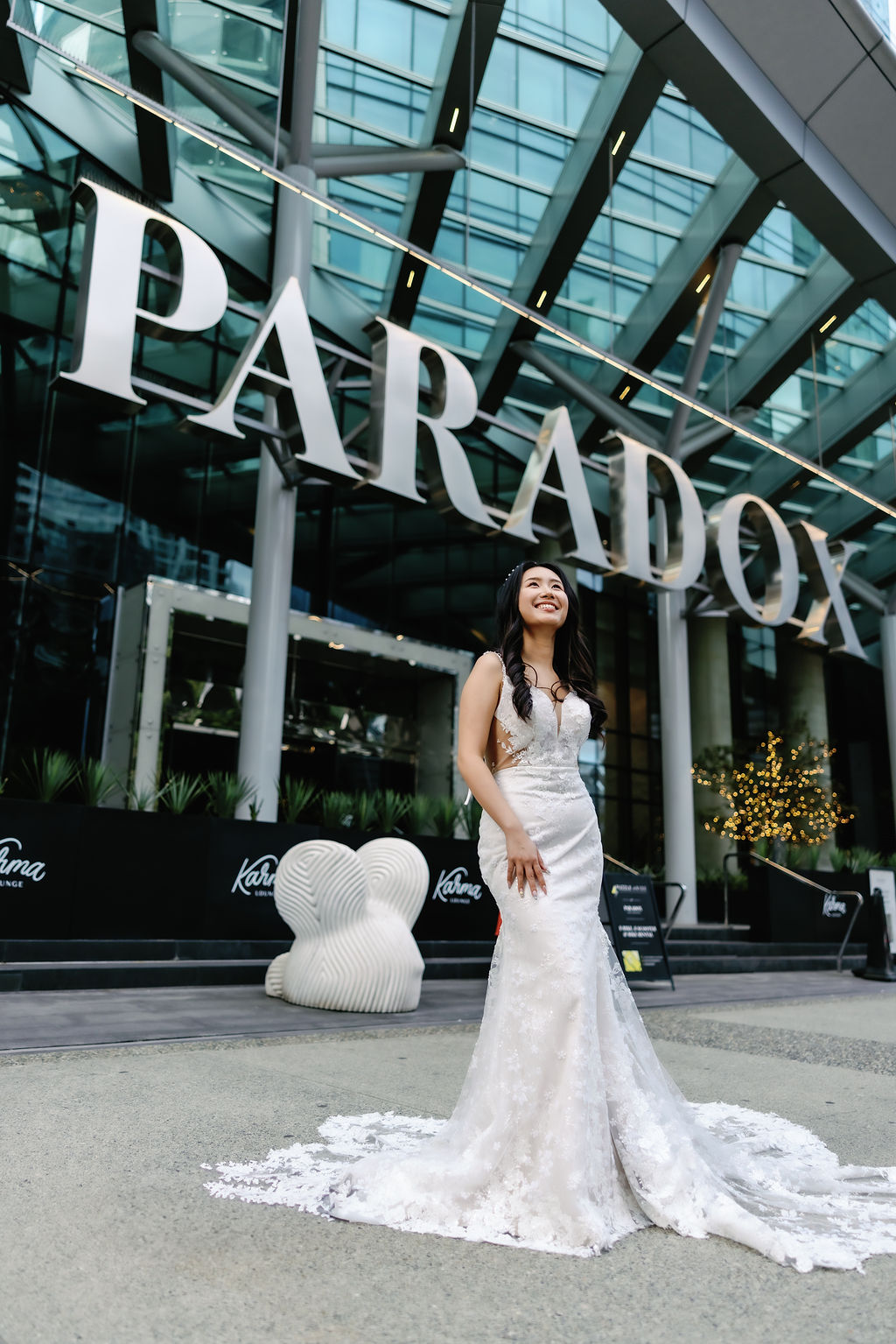 bride laughs in front of Paradox Vancouver sign